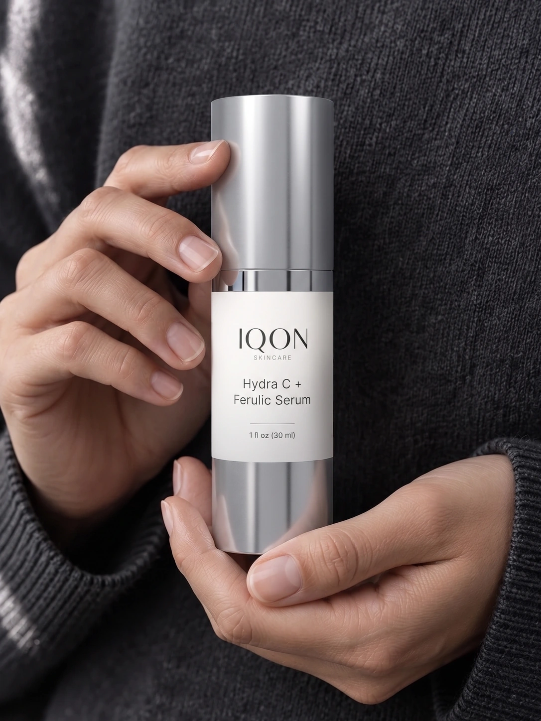 Hands holding IQON Hydra C + Ferulic Serum as part of a daily skincare ritual
