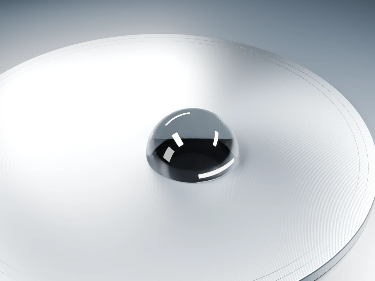 A clear droplet on a brushed silver surface